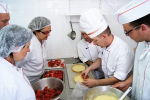 employés de restauration collective réalisant des pâtisseries élaborées