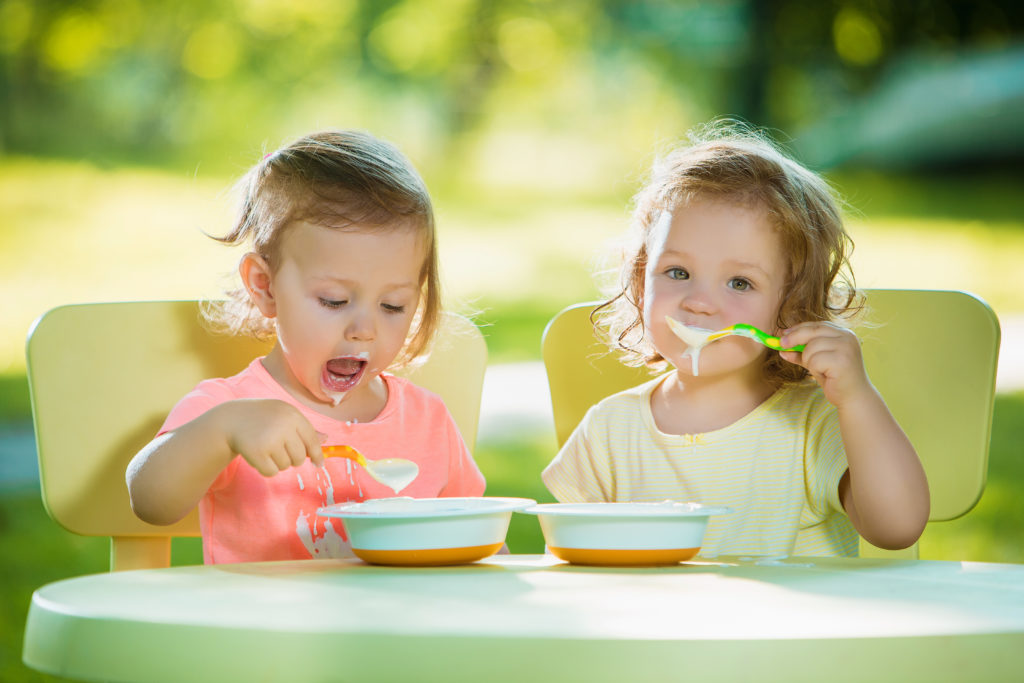Deux petites filles mangeant un repas à la crèche